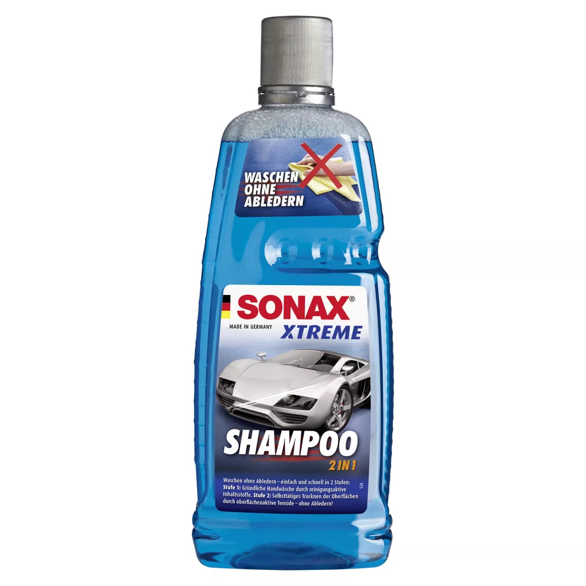 Bild einer 1-Liter-Flasche Sonax Xtreme Shampoo 2-in-1 von SONAX. Die transparente Flasche zeigt die blaue Flüssigkeit im Inneren und zeigt ein Autobild sowie den Text „SONAX Xtreme Shampoo 2 in 1“ und „Waschen ohne Abtrocknen“ auf Deutsch auf dem Etikett, was die fleckenfreie Trocknungsformel hervorhebt. Die Flasche ist mit einer silbernen Kappe versehen.